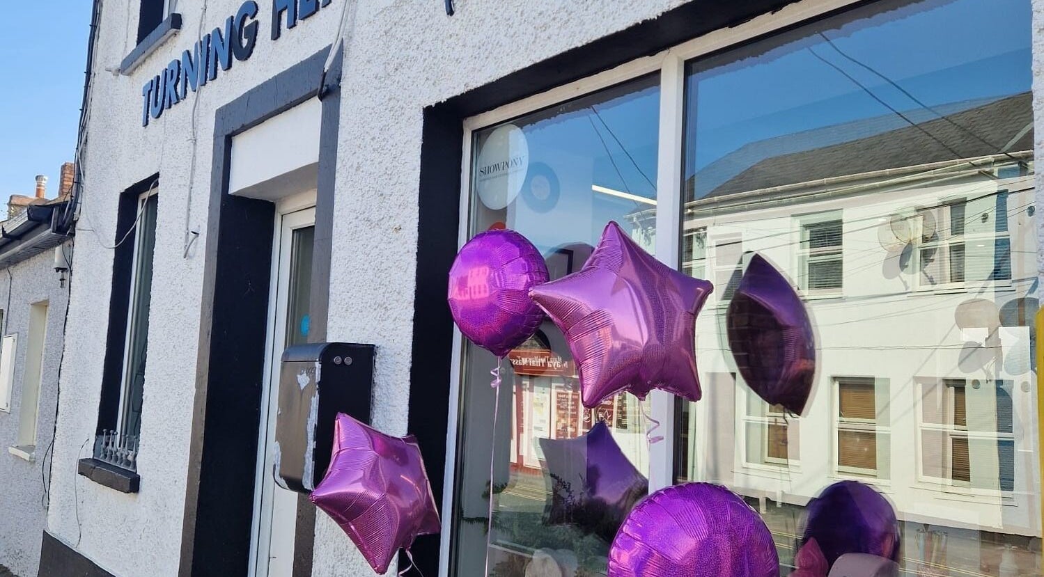 Front of Hand's Up Nail Bar in Cork, Ireland with vibrant purple balloons adorning the entrance.