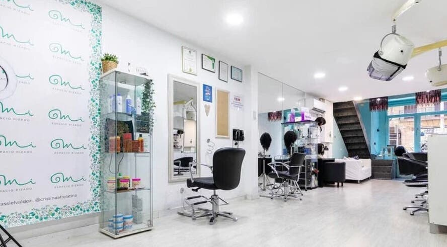 Interior moderno de Mi Espacio Rizado Sepúlveda en Barcelona, Catalunya, ES, mostrando sillas y espejo.