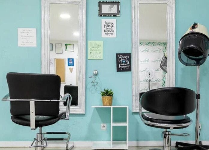 Interior elegante de Mi Espacio Rizado Sepúlveda en Barcelona, Catalunya, ES con sillas y espejo.