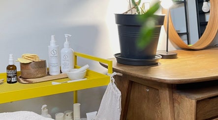 Wellnessruimte bij Mariachi, Mechelen, Vlaams Gewest BE met verzorgingsproducten en een houten tafel.