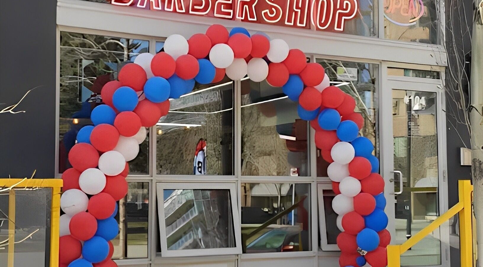 Colorful balloon arch outside Ev Cut Barbershop in Calgary, Alberta, CA welcoming visitors.