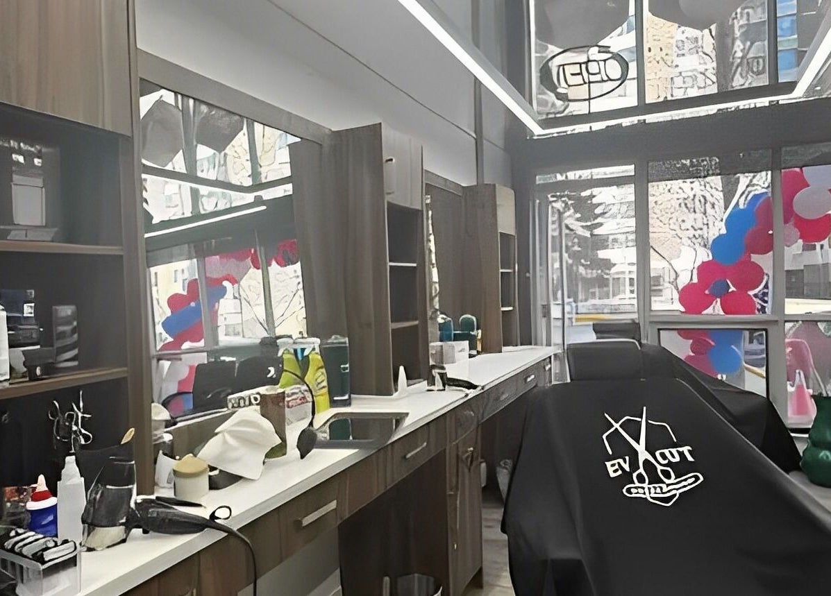 Interior of Ev Cut Barbershop in Calgary, Alberta, CA, showcasing modern chairs and sleek mirrors.