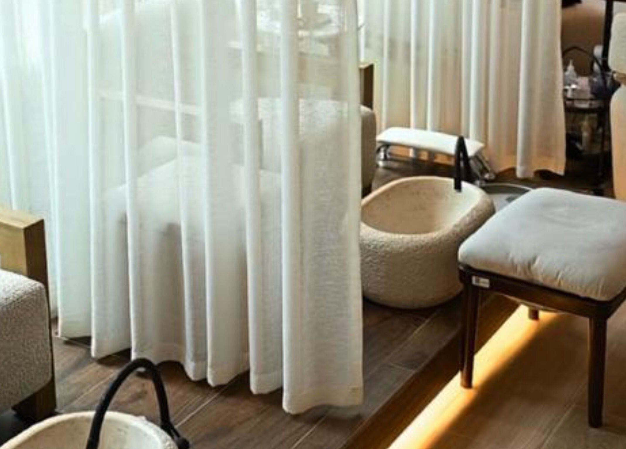 Calming pedicure area at LW Nail Bar, Riyadh. Features plush seating and basins for a relaxing experience.