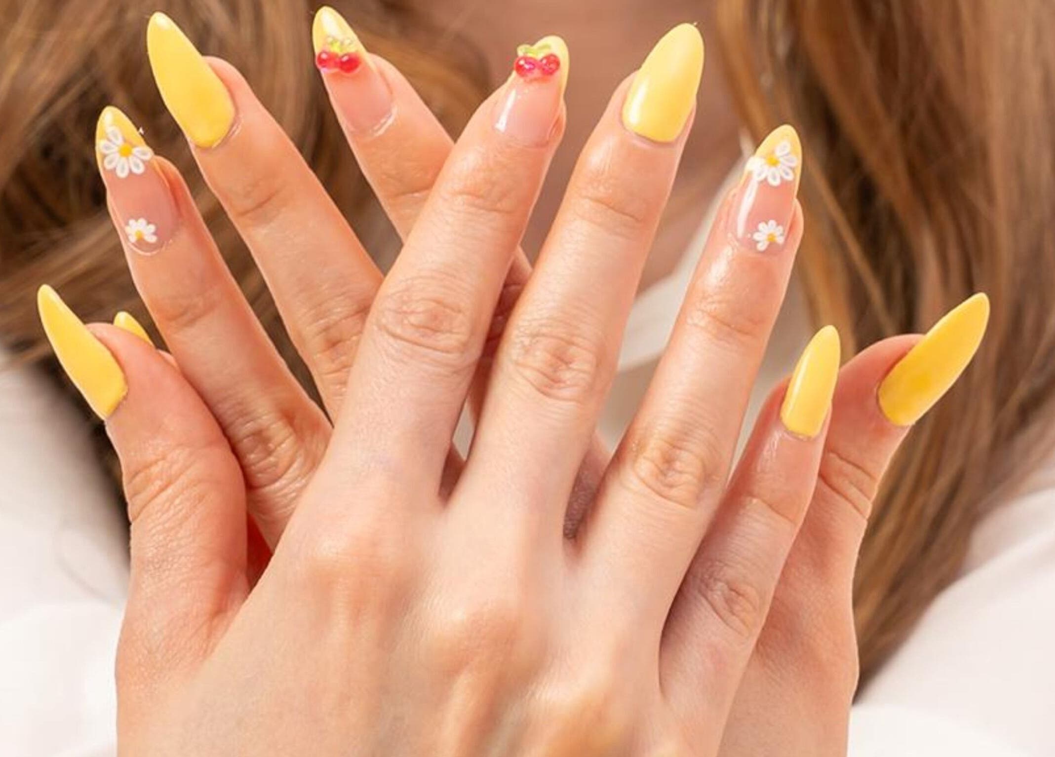 Bright yellow nail art with floral designs at LW Nail Bar, Riyadh, Riyadh Province, SA.