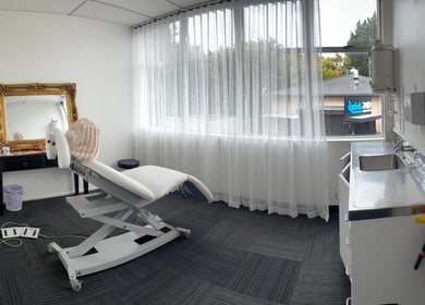 Bright treatment room at Viva Dentures, Auckland, NZ, featuring a comfortable chair and elegant mirror.