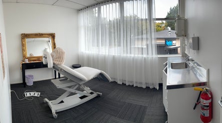 Bright treatment room at Viva Dentures, Auckland, NZ, featuring a comfortable chair and elegant mirror.