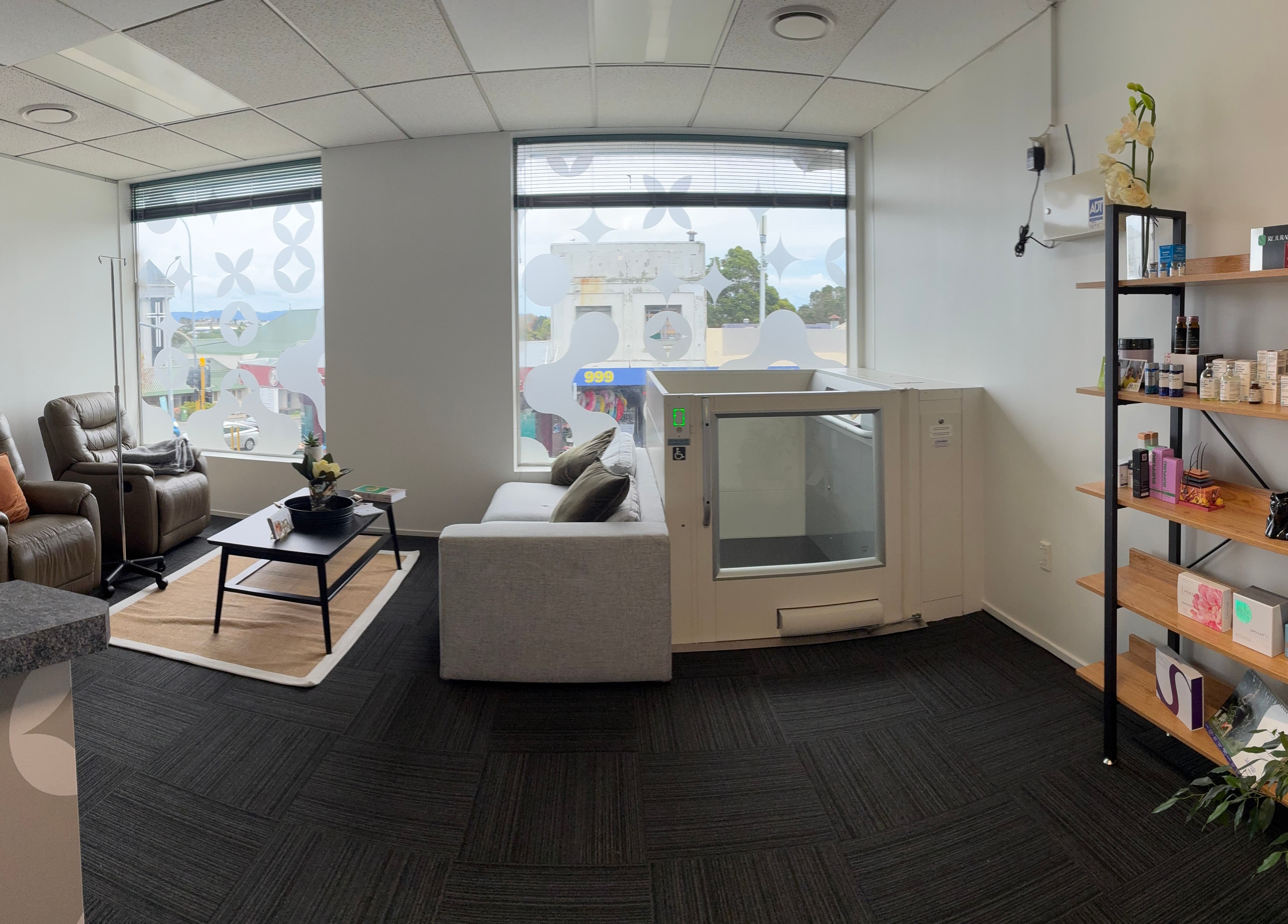 Modern interior of Viva Dentures in Auckland, NZ showcasing cozy seating and wellness products.