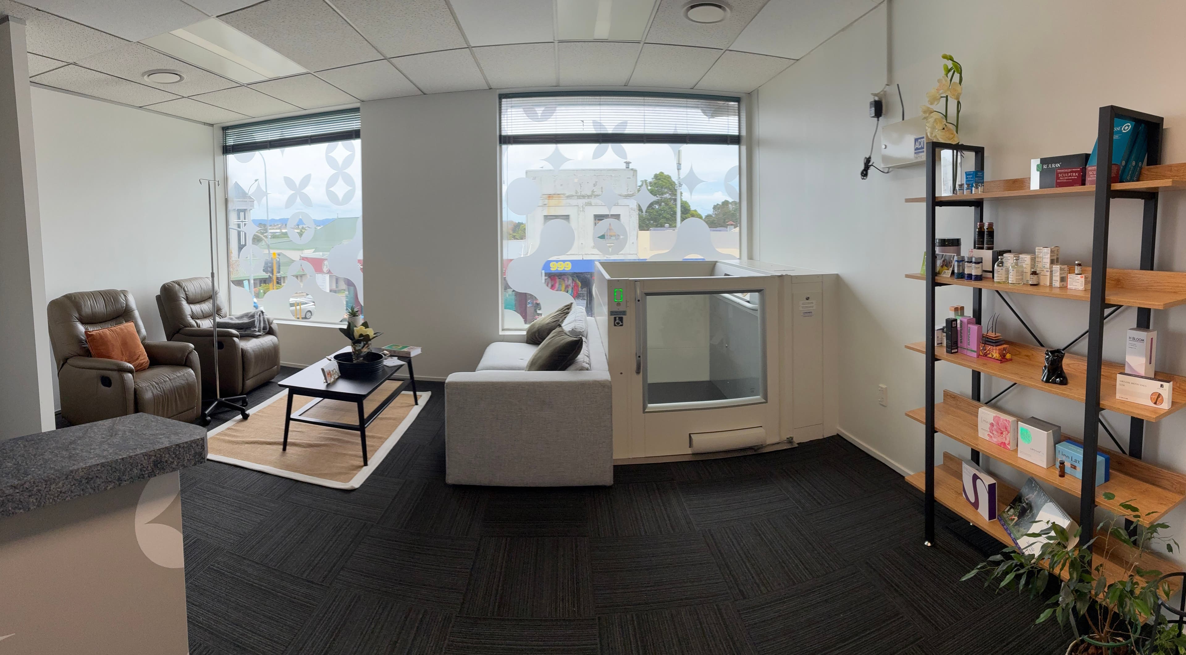 Modern interior of Viva Dentures in Auckland, NZ showcasing cozy seating and wellness products.
