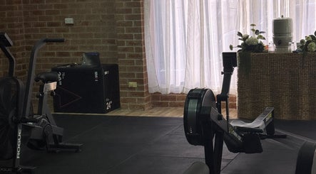 Exercise equipment in a well-lit gym at Shift, Fairy Meadow, New South Wales, AU with soft curtains and plants.