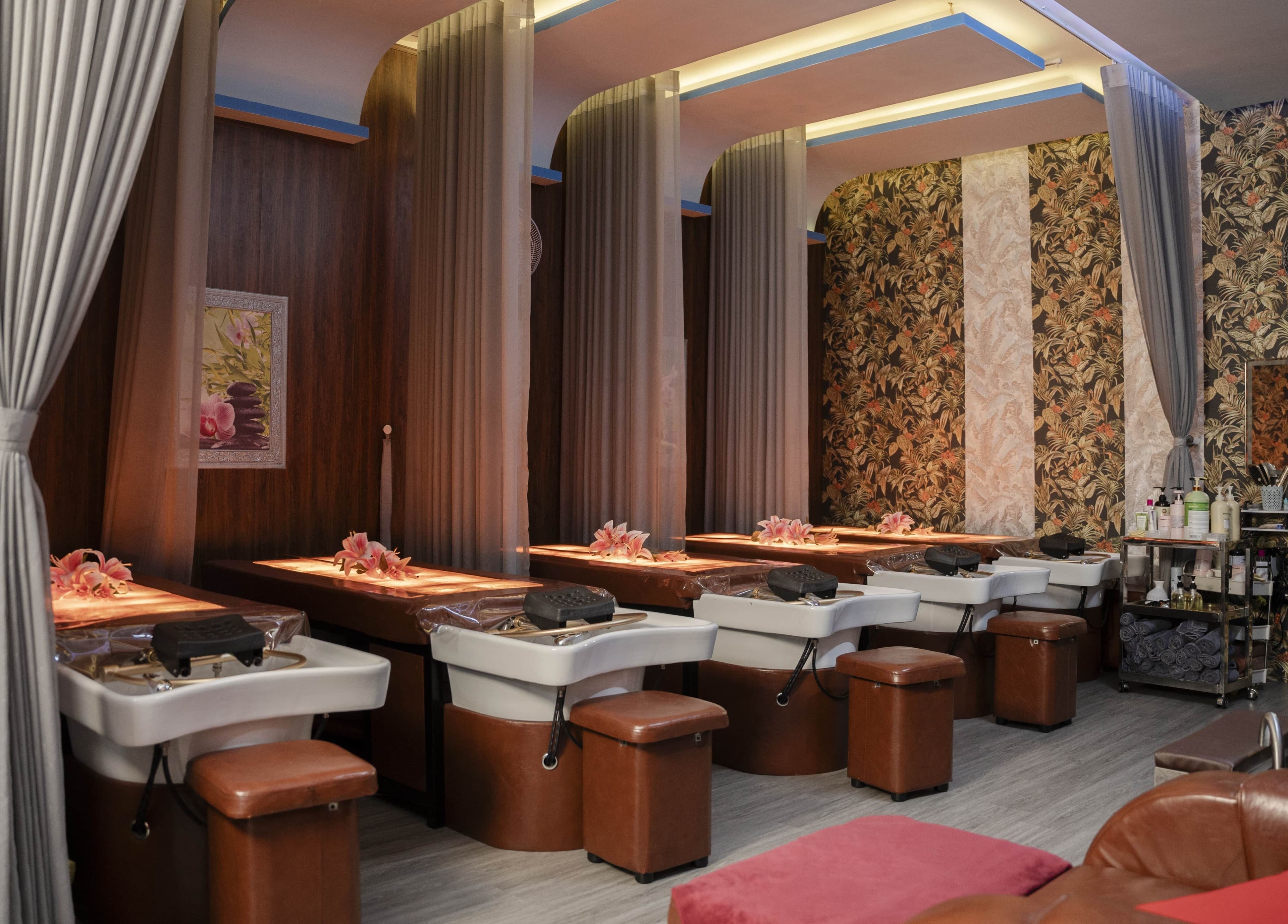 Không gian thư giãn sang trọng tại Solis Spa, Đà Nẵng, Đà Nẵng, VN với giường mát-xa và hoa trang trí.