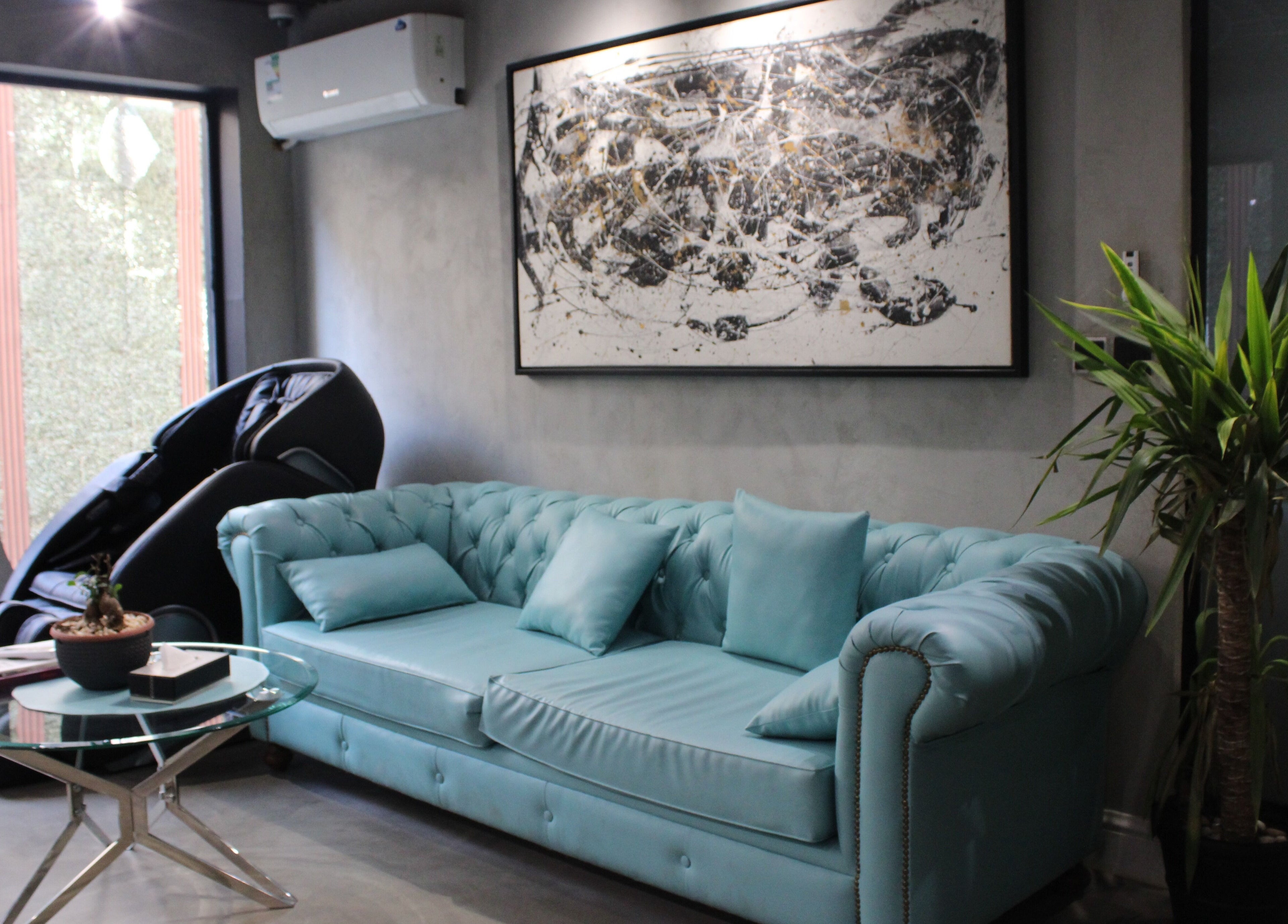 Stylish waiting area at Scissor's Experts Salon in Riyadh, featuring a teal sofa and modern decor.