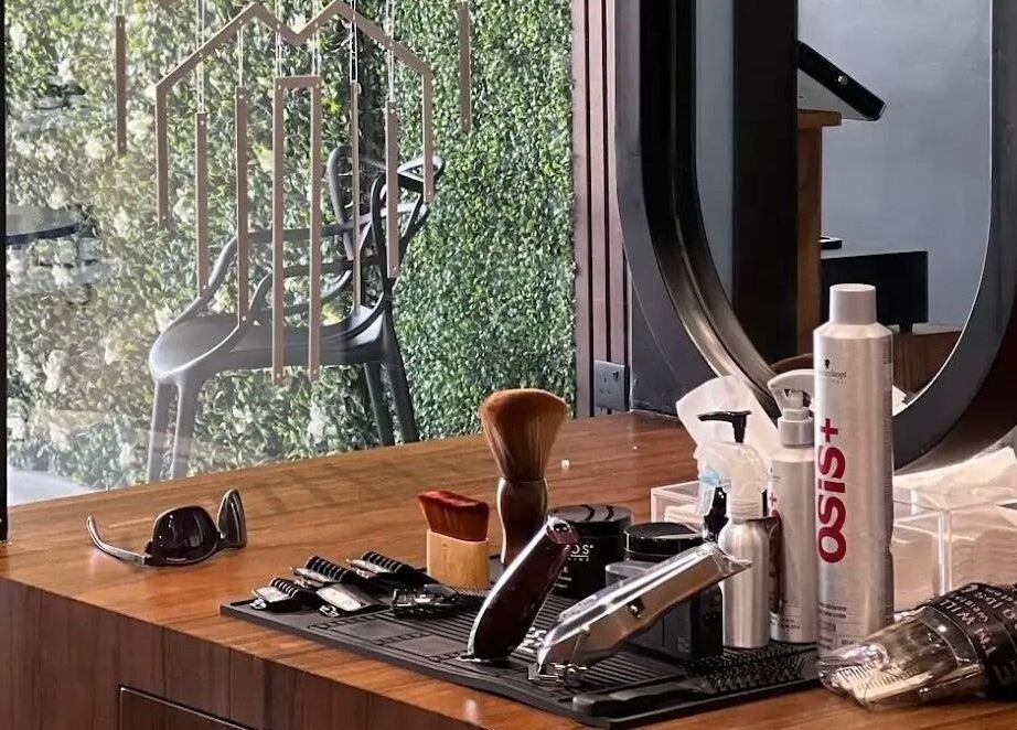 Grooming tools on a wooden counter at صالون خبراء المقص للحلاقة الرجالية - Scissor's Experts Salon in الرياض, SA.