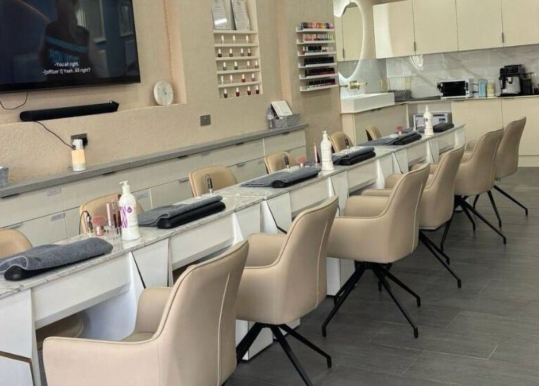Chic nail salon interior at Go Glam, London, England, GB, featuring sleek manicure stations and plush chairs.