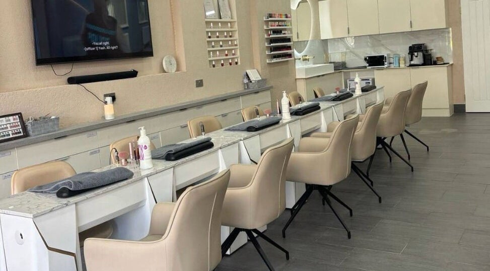 Chic nail salon interior at Go Glam, London, England, GB, featuring sleek manicure stations and plush chairs.