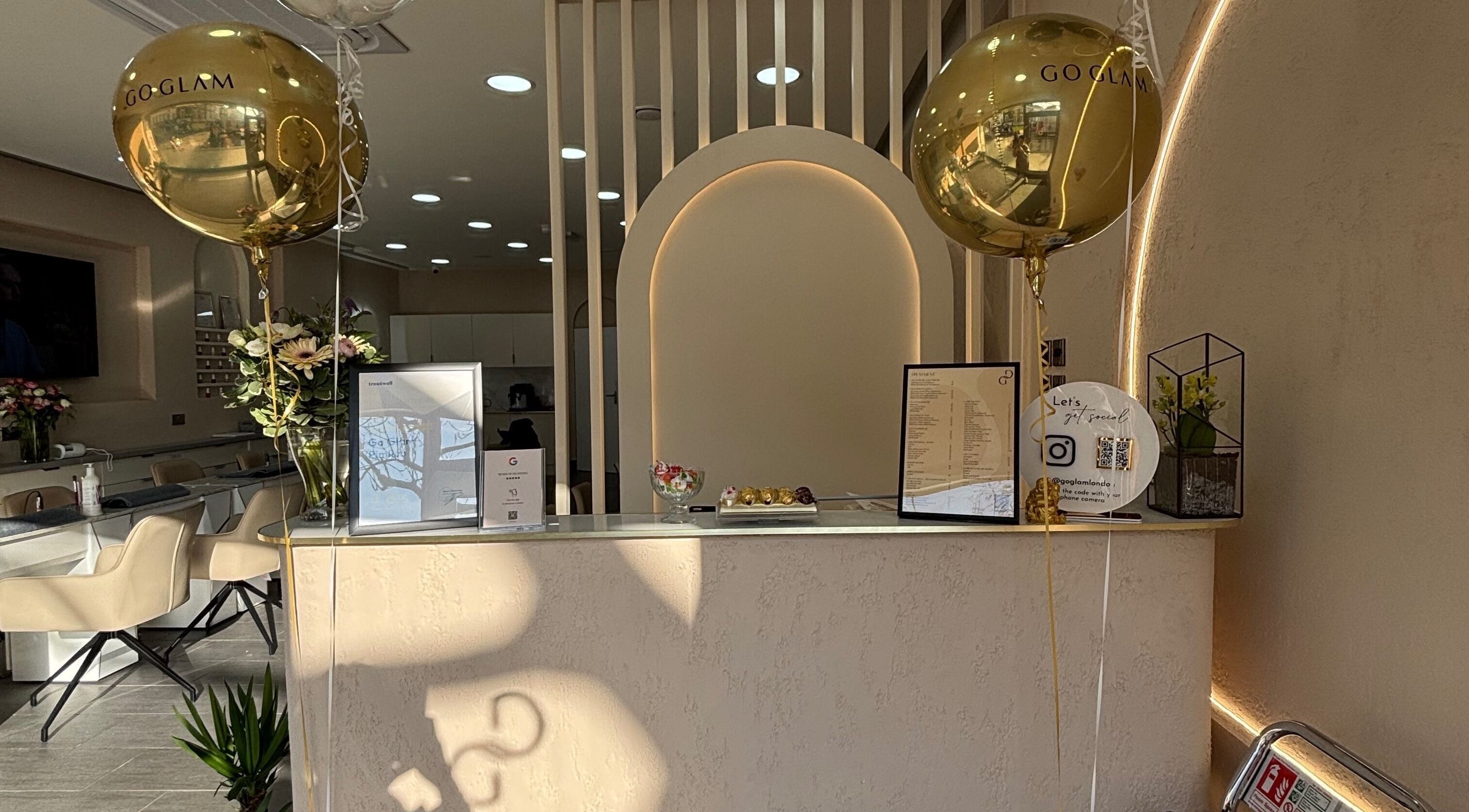 Chic reception area at Go Glam, London, England, GB featuring gold balloons and elegant decor.