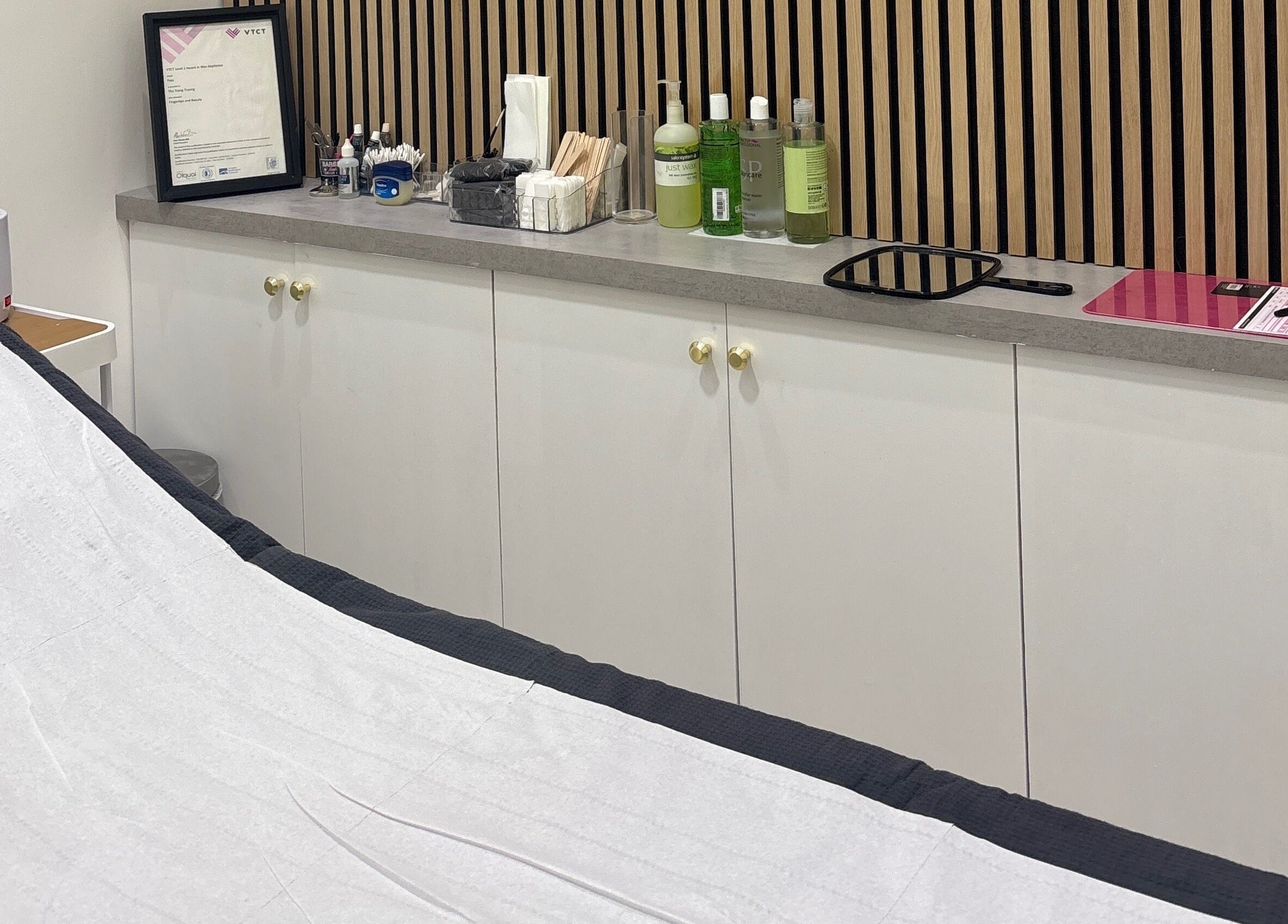Treatment room at Go Glam, featuring a bed and skincare products in London, England, GB.