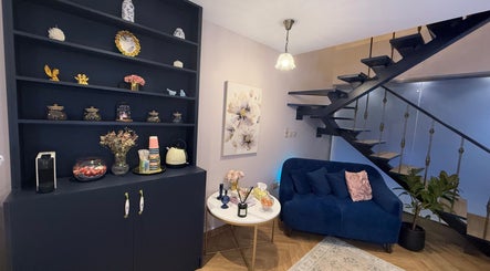 Elegant lounge at Nailful Salon, Jeddah, Makkah Province, SA, featuring a stylish sofa and decorative accents.
