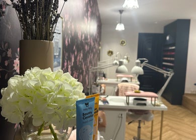 Elegant interior of Nailful Salon in Jeddah, Makkah Province, SA with floral decor and cozy seating.