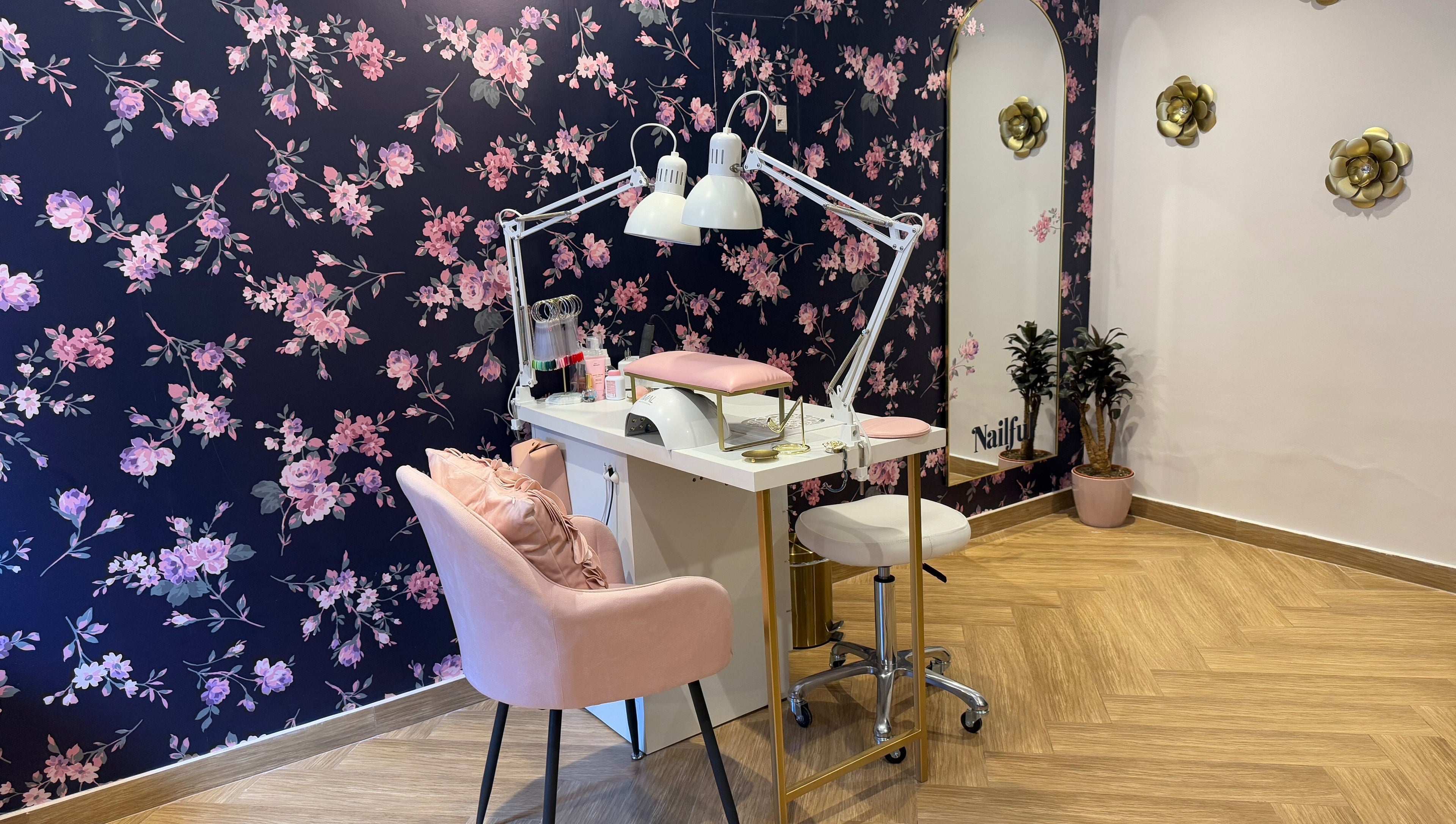Chic nail station at Nailful Salon, Jeddah, Makkah Province, SA, with floral wall and pink seating.