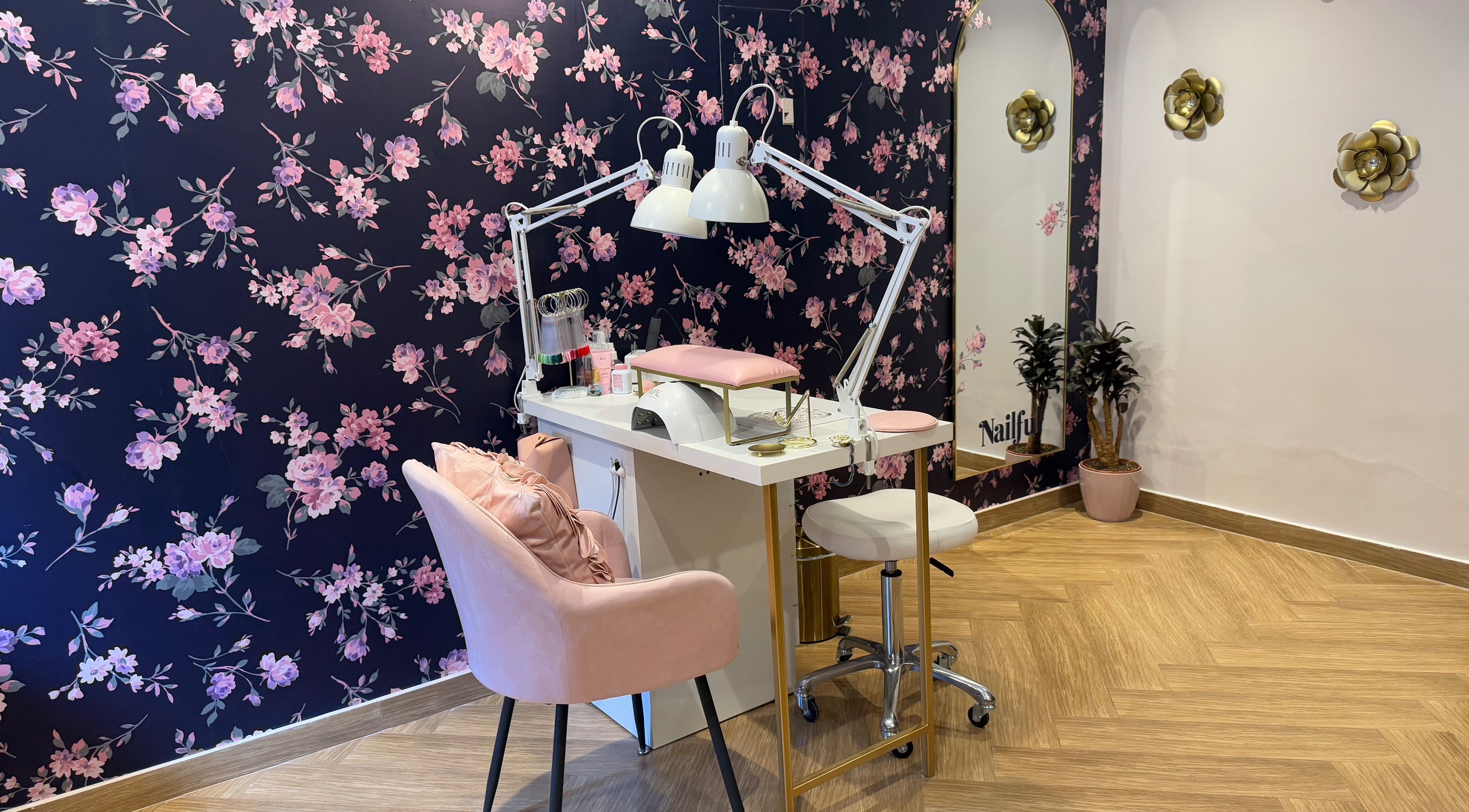 Chic nail station at Nailful Salon, Jeddah, Makkah Province, SA, with floral wall and pink seating.