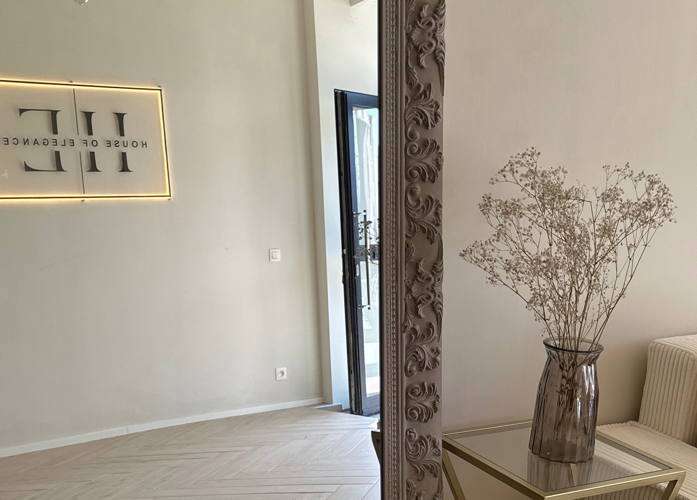 Interieur van House of Elegance, Antwerpen, met spiegel en bloemen op tafel.