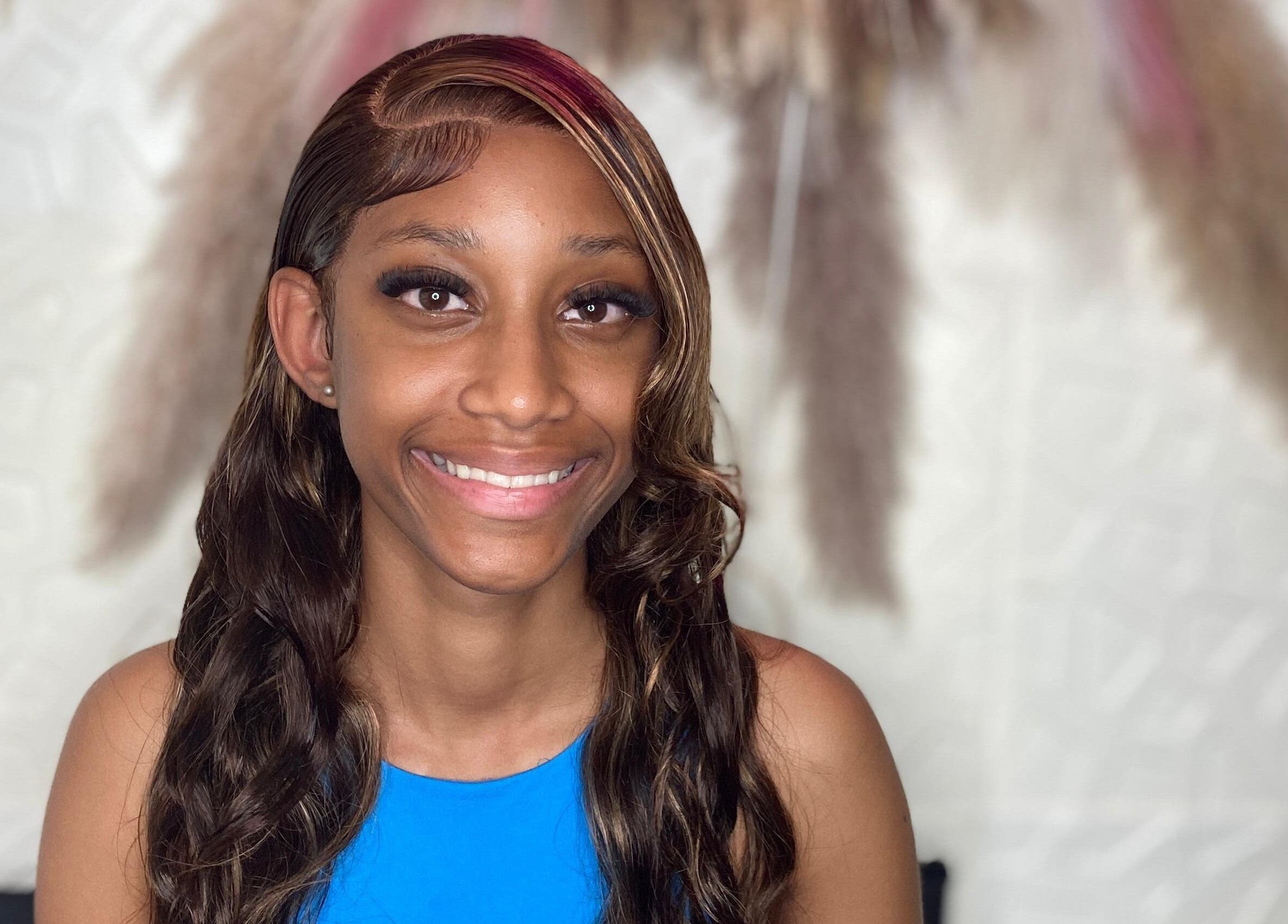 Smiling client with styled hair at Styles By Kera, Roseau, Saint George Parish, DM.