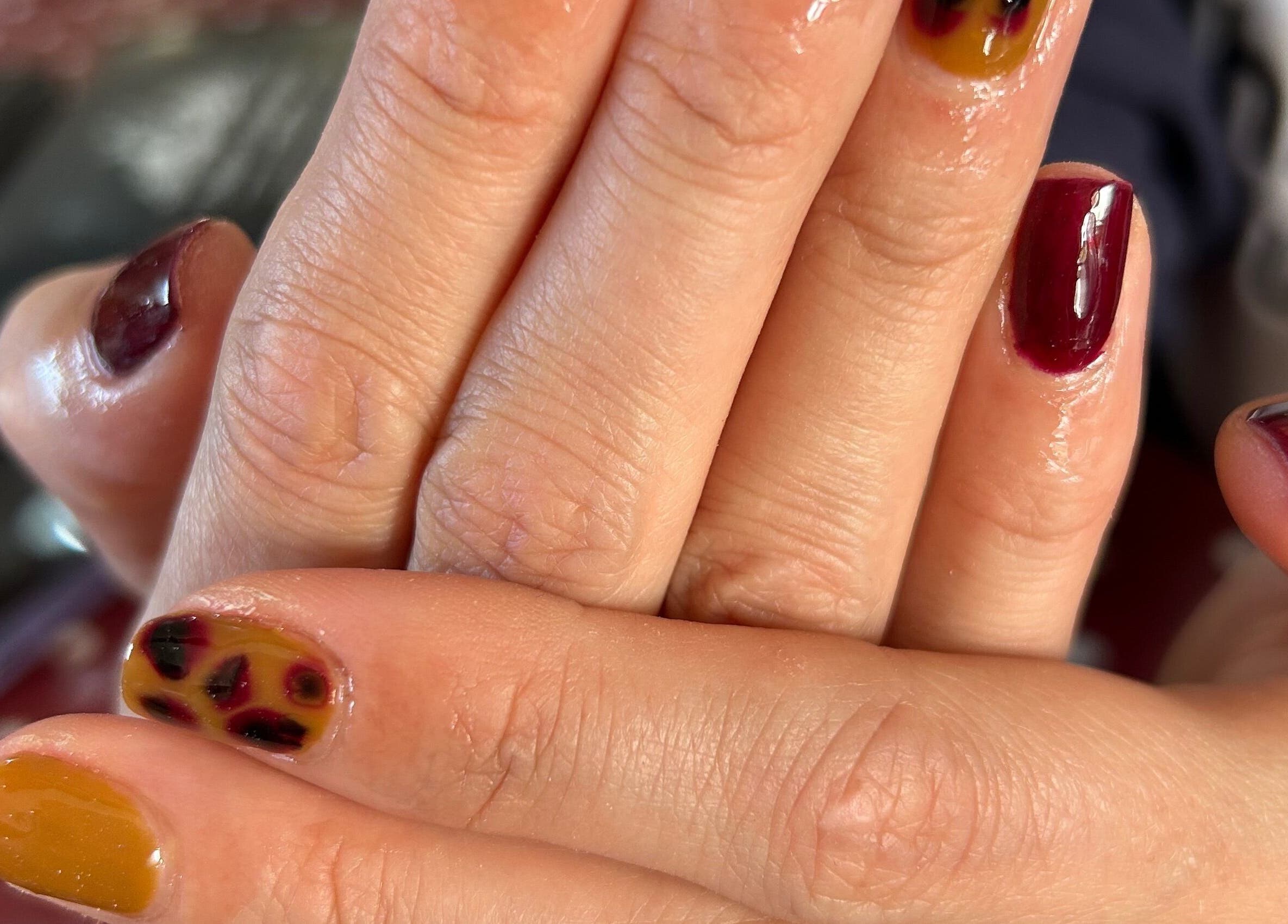 Colorful nail art at Nails By El, Thurmaston, England, GB, featuring vibrant maroon and yellow designs.