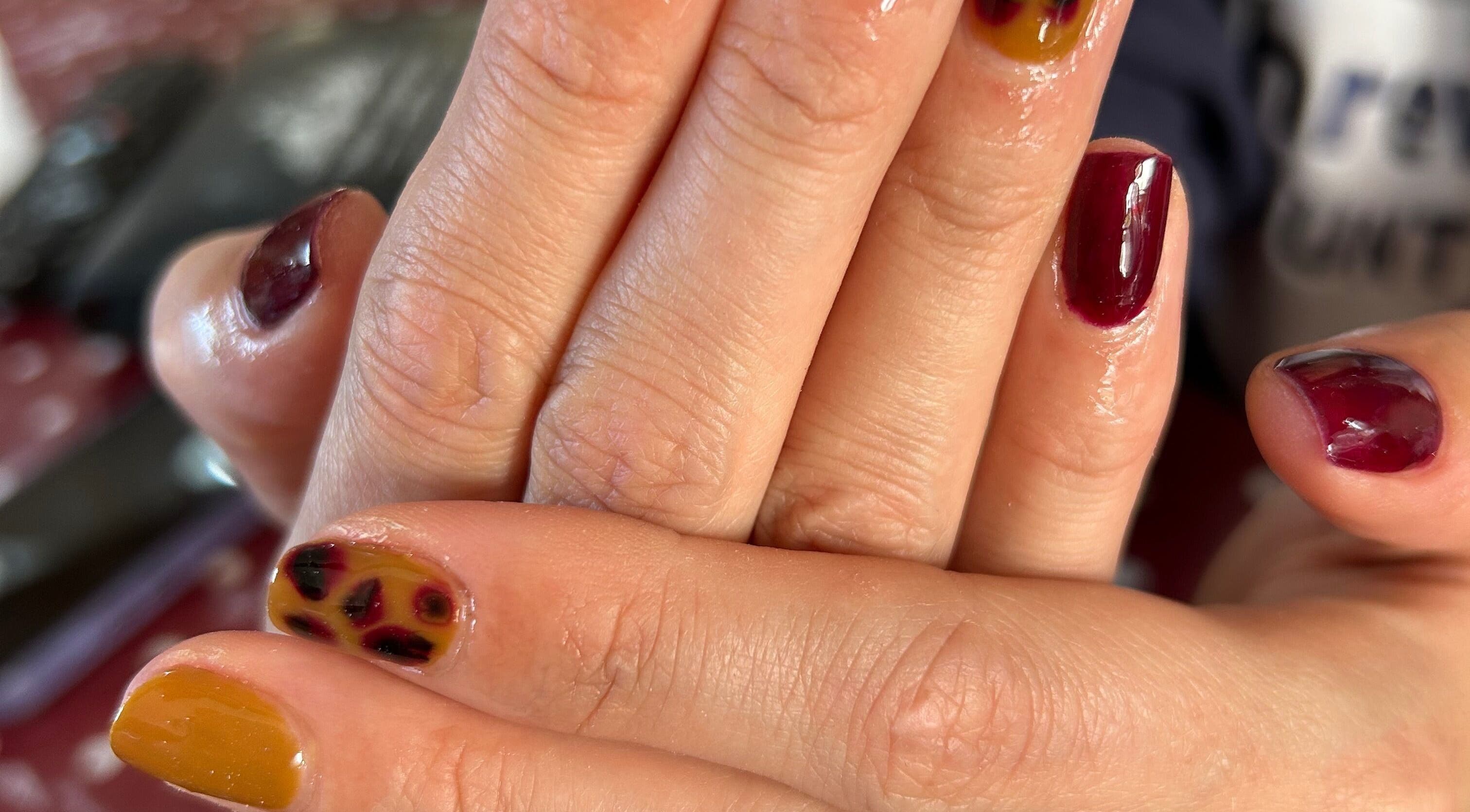 Colorful nail art at Nails By El, Thurmaston, England, GB, featuring vibrant maroon and yellow designs.