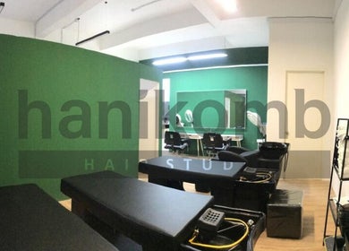 Modern styling area at Hanikomb Hair Studio in Johor Darul Ta'zim, MY with sleek green and black interior.