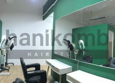 Modern interior of Hanikomb Hair Studio, Johor Darul Ta'zim, with sleek mirrors and styling chairs.
