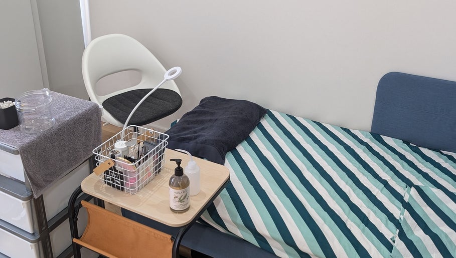 Cozy treatment area at Tokyo eyelash in Kilburn, South Australia, AU with striped bed and stylish decor.