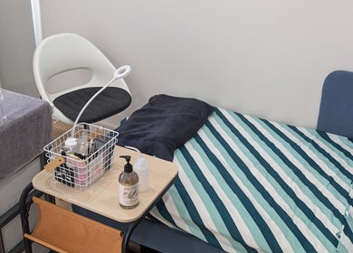 Cozy treatment area at Tokyo eyelash in Kilburn, South Australia, AU with striped bed and stylish decor.