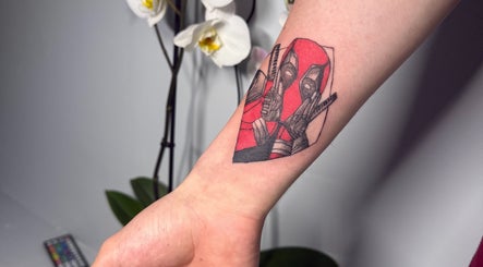 Colorful arm tattoo at Hellhouse salon, Norwich, England, GB, showcasing intricate art and design.