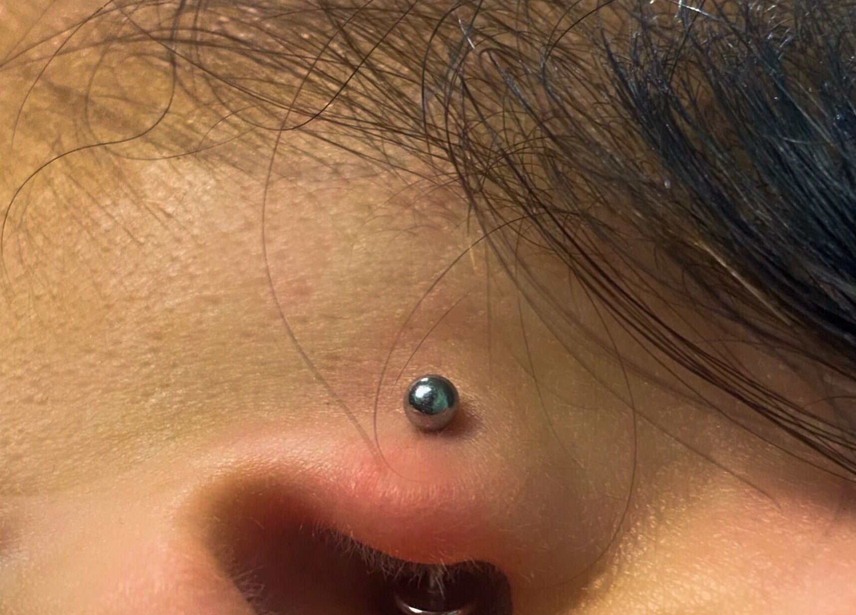 Piercing elegante no rosto, realizado por Cristiana body piercer em Faro, Faro, PT.