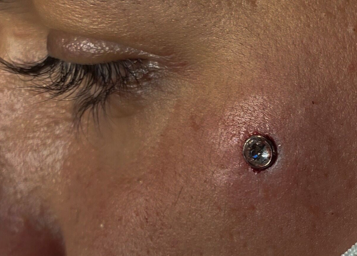 Close-up de piercing facial com pedra brilhante na Cristiana body piercer, Faro, Faro, PT.