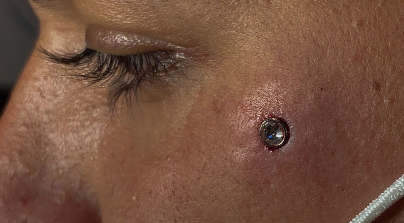 Close-up de piercing facial com pedra brilhante na Cristiana body piercer, Faro, Faro, PT.