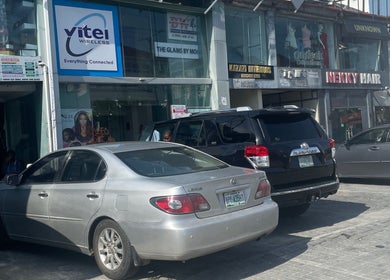 Exterior view of HairByTreapotter salon in Lagos, Lagos, NG, showcasing parking area and vibrant signage.