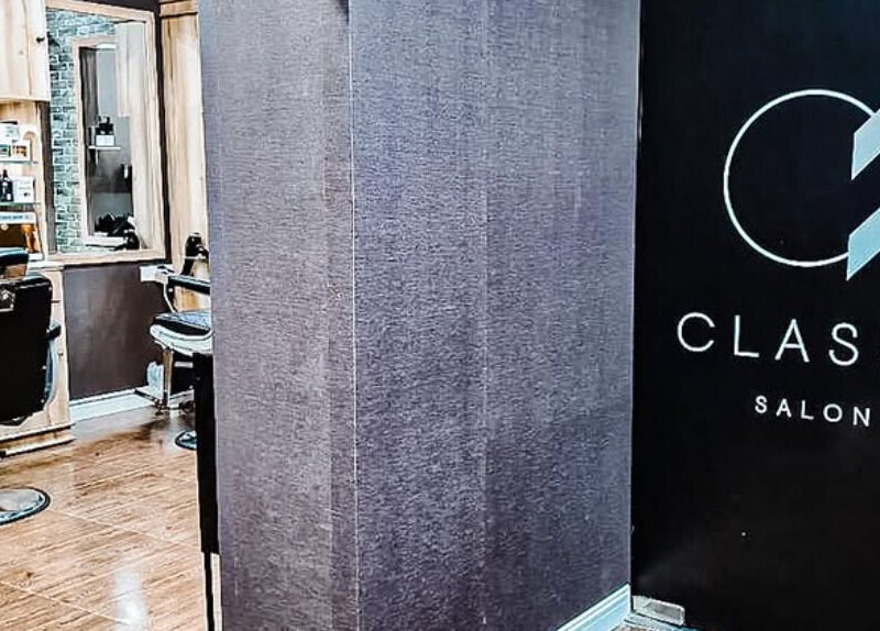 Modern interior of Classy Salon in Ajman, AE with sleek black chairs and well-lit mirrors.