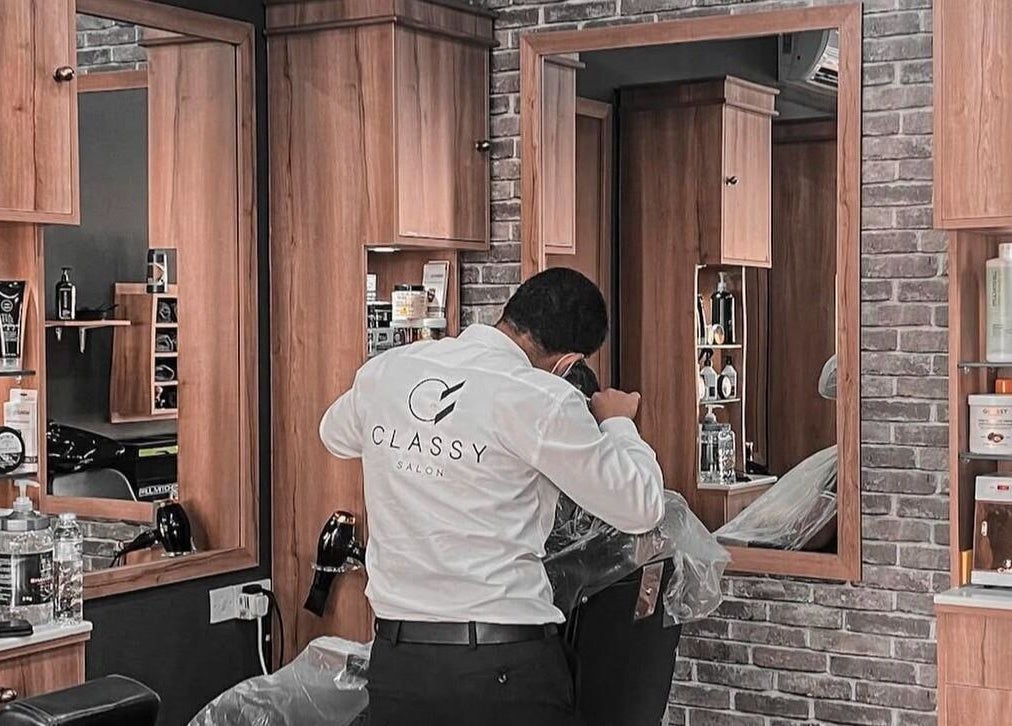 Classy Salon hairstylist in action at Ajman, Ajman, AE, surrounded by premium salon products.