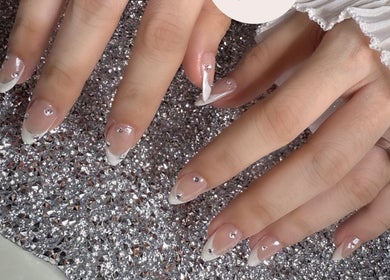 Elegant nail art with gems at Nails By Nks, Phnom Penh, Phnom Penh, KH on a shimmering background.