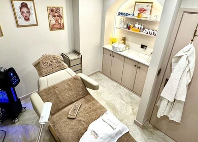 Elegant treatment room at Shefa Beauty Lounge, London, England, showcasing spa bed and skincare products.