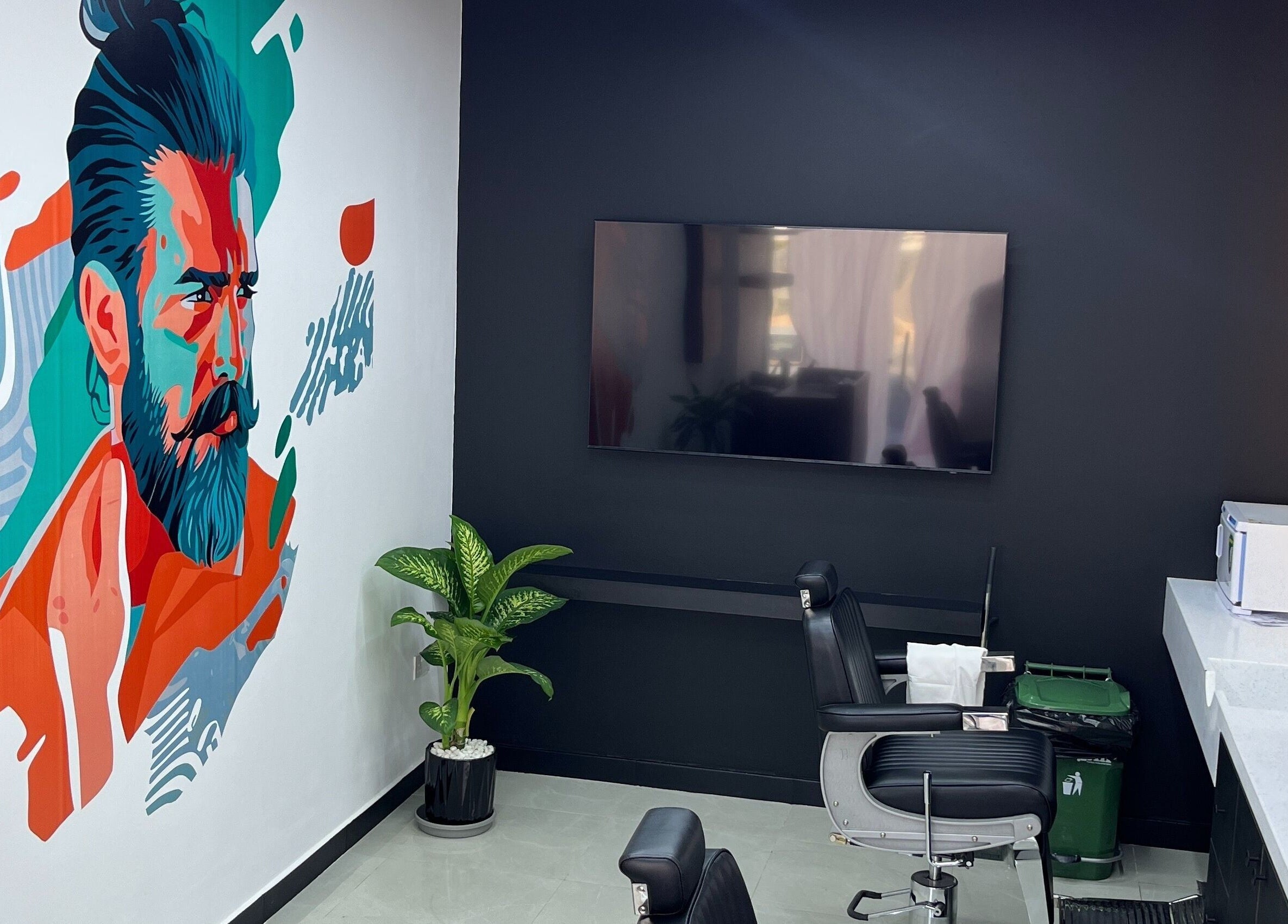 Interior of Faridbarbershop in Muscat, Muscat Governorate, OM, featuring colorful wall art and a sleek barber chair.