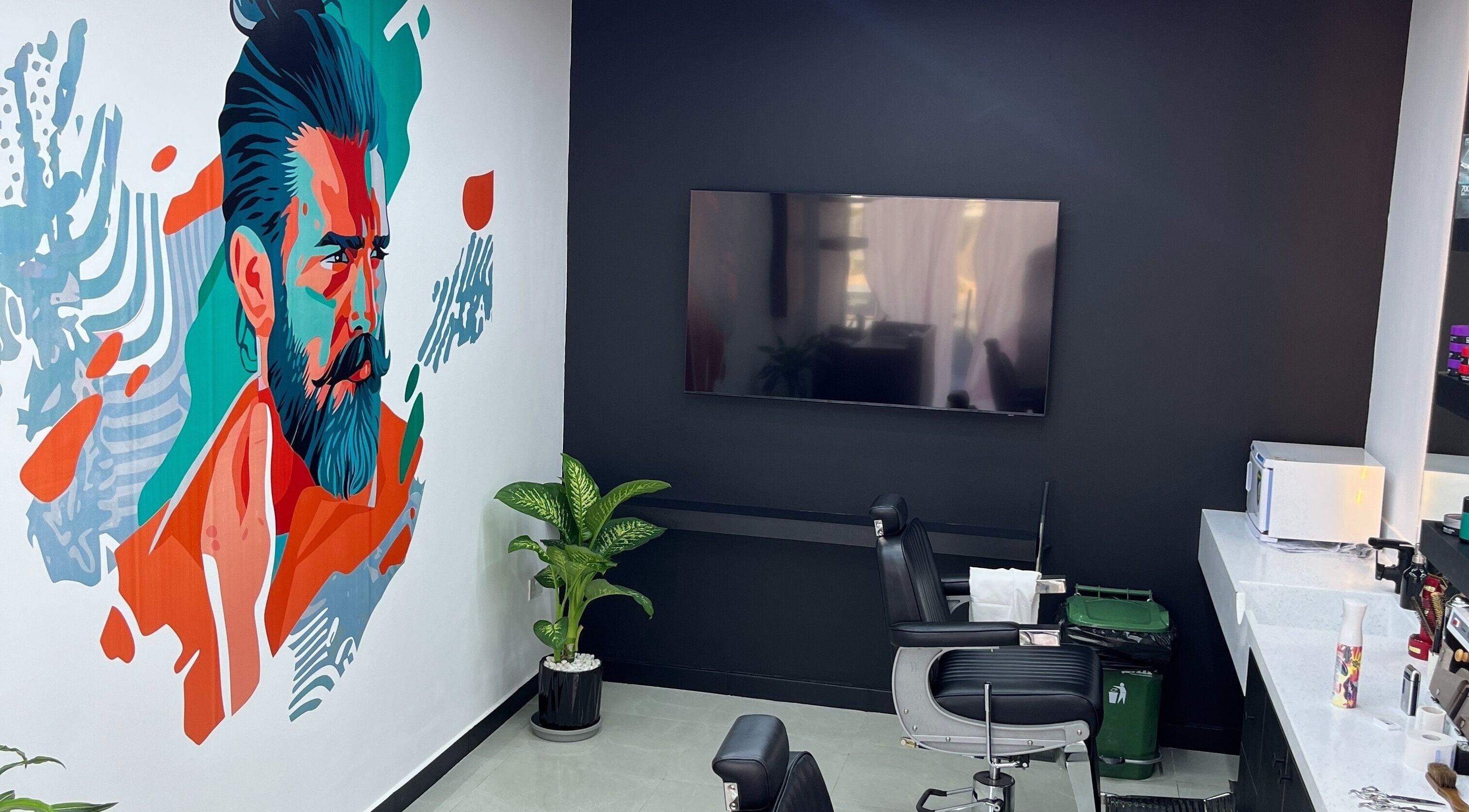 Interior of Faridbarbershop in Muscat, Muscat Governorate, OM, featuring colorful wall art and a sleek barber chair.
