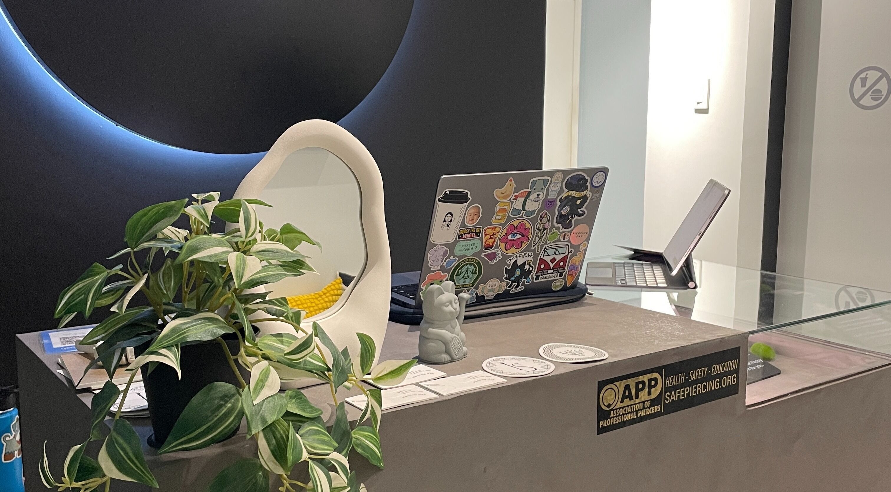 Reception desk with laptops at Piercing Day, Taguig, Metro Manila, PH, showcasing modern decor.