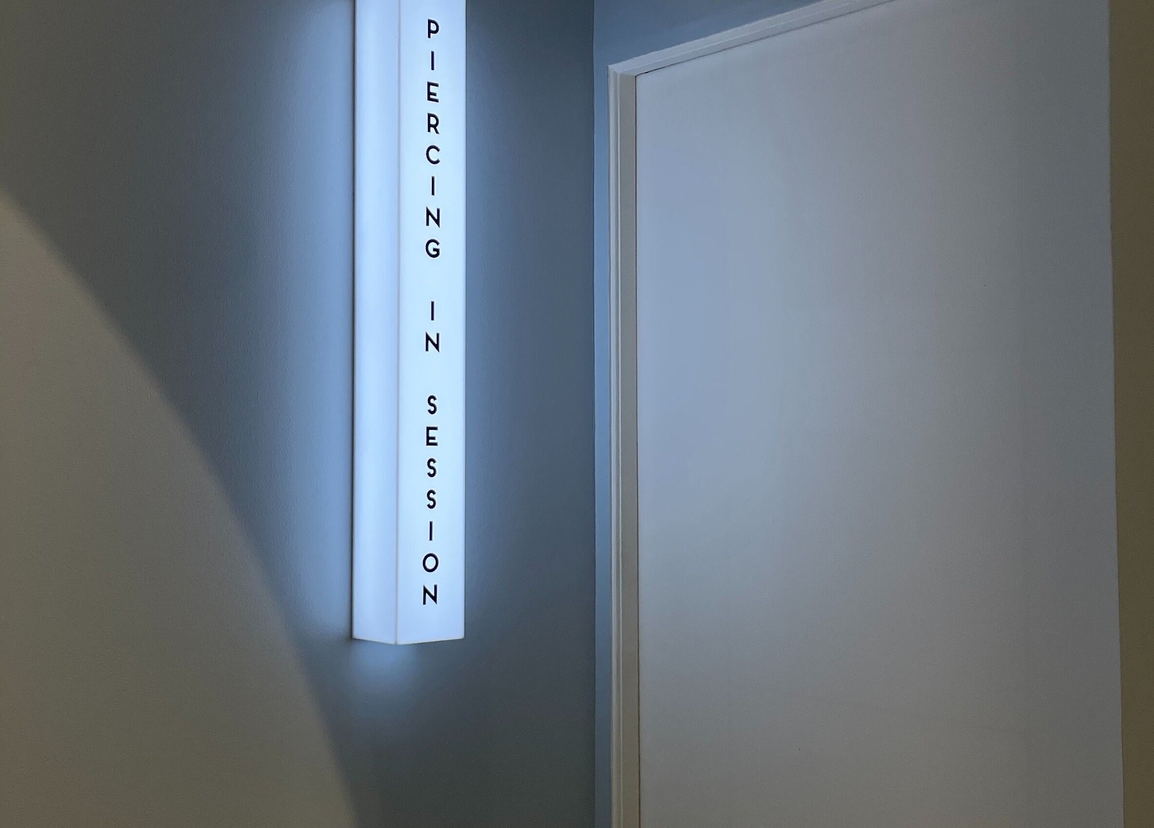 Illuminated 'Piercing in Session' sign at Piercing Day, Taguig, Metro Manila, PH indicates professionalism.