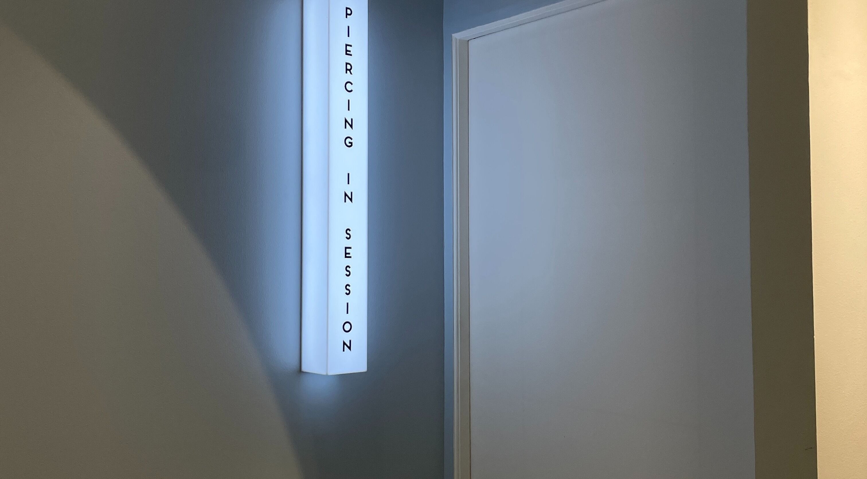 Illuminated 'Piercing in Session' sign at Piercing Day, Taguig, Metro Manila, PH indicates professionalism.