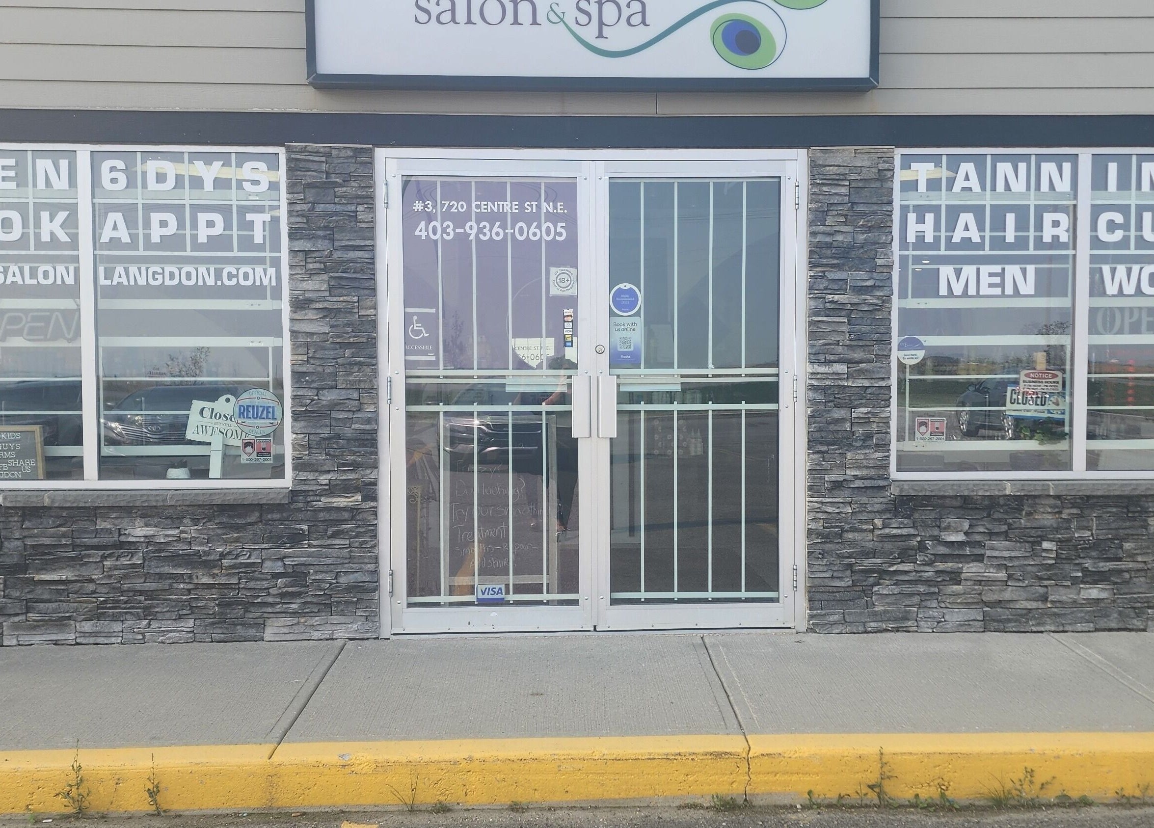 Front entrance of Divine Salon and Spa in Langdon, Alberta, CA with booking signs.