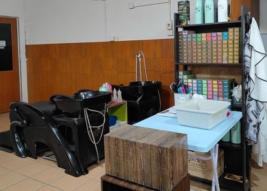 Modern wash area at 008 Hair & Beauty Studio, Ipoh, Perak, MY, showcasing sleek black chairs and vibrant products.