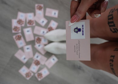 Close-up of a hand holding Evil Eye Lash Bar business card, Melbourne, Victoria, AU.