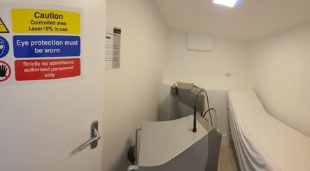 Treatment room at Citrine Clinic, Ilford, England, GB with laser equipment and safety signs.